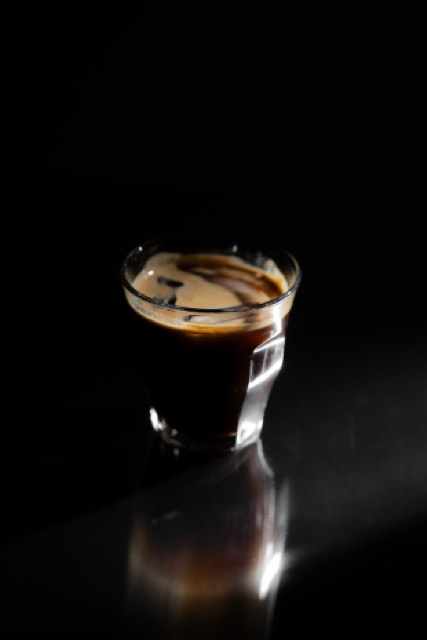 Espresso im Glas vor dunklem Hintergrund