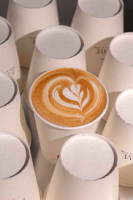 Cappuccino mit Latte Art zwischen FAVE Bechern